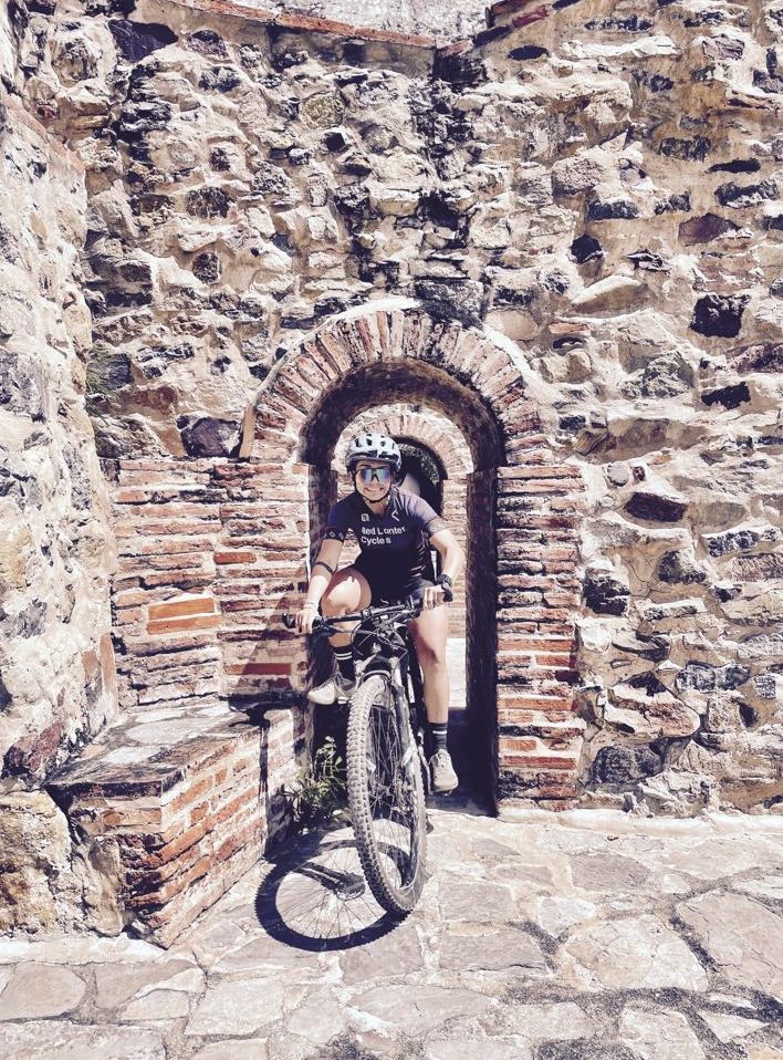A rider passing through a stone archway